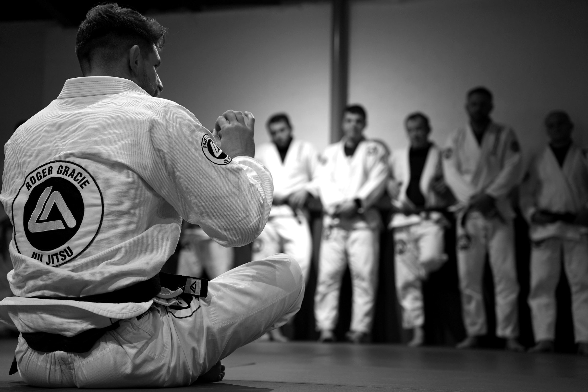 A black belt instructor teaching a line of adult members