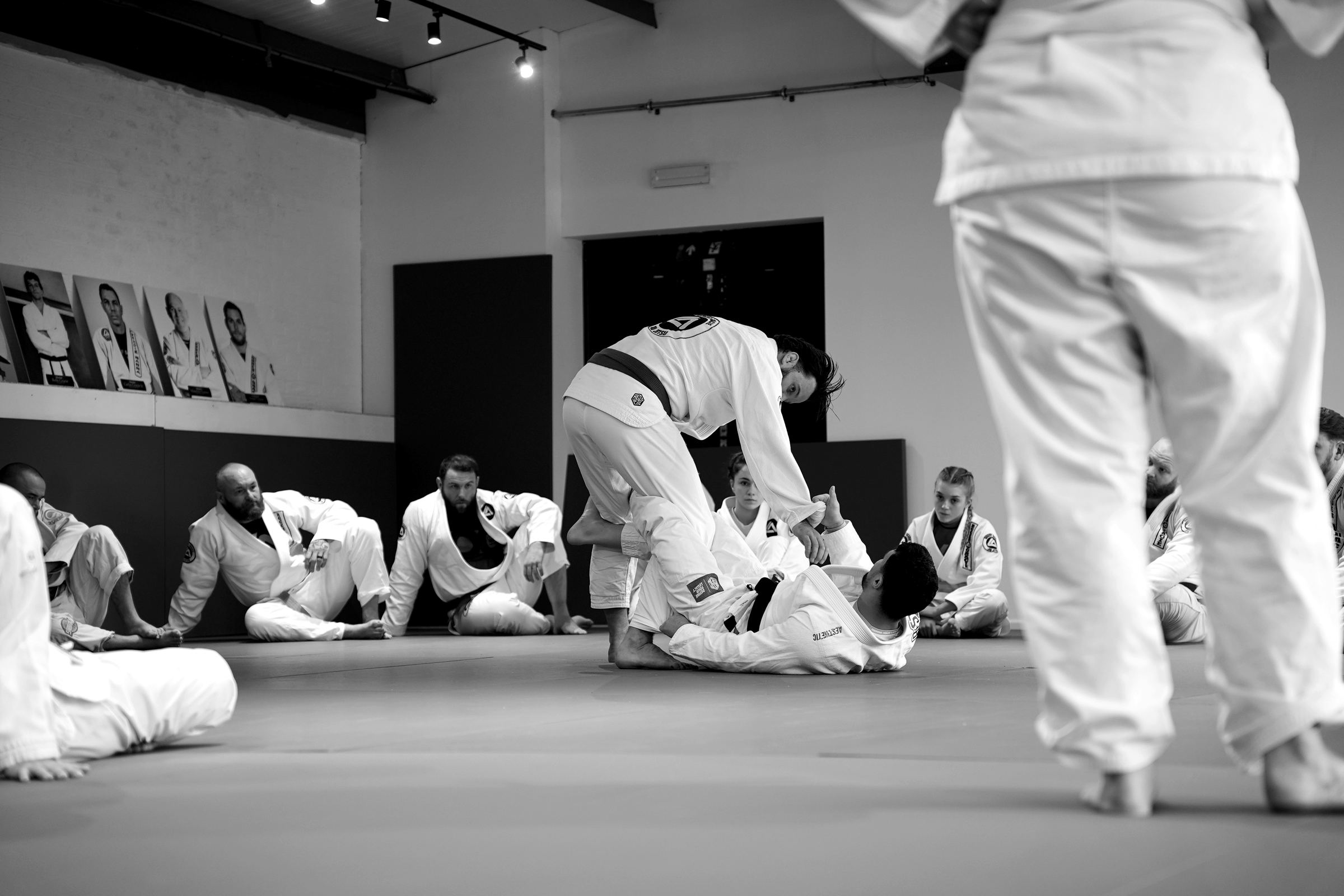 Members sitting round the mat watching a technique demonstration